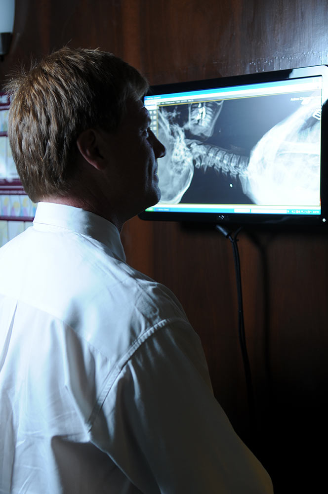 Dr. Anthon looking at an x ray of a person's head and neck 